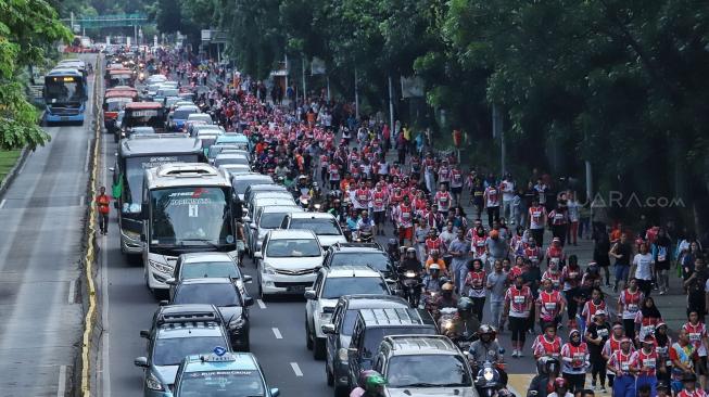 Sejumlah peserta berlari saat mengikuti acara Bela Negara Run 2018 di Jalan Merdeka Barat, Jakarta, Minggu (16/12). [Suara.com/Muhaimin A Untung]