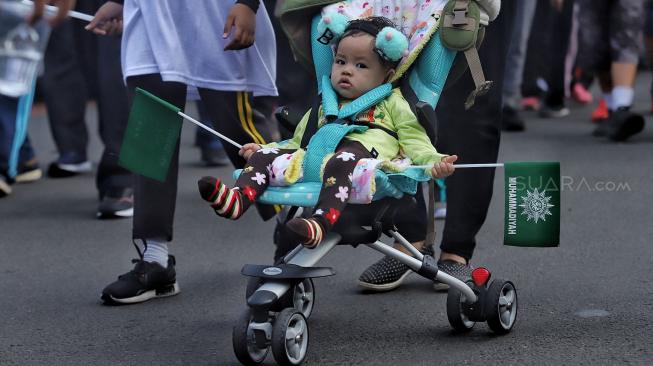 Sejumlah peserta mengikuti jalan santai keluarga besar Muhammadiyah DKI jakarta di Silang Barat Daya Monas, Jakarta, Minggu (16/12). [Suara.com/Muhaimin A Untung]