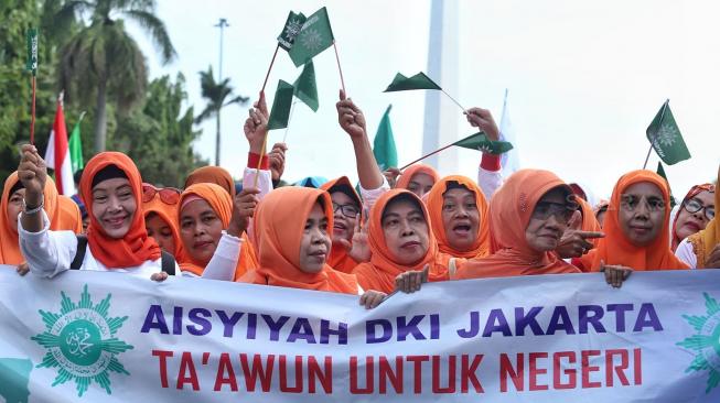 Sejumlah peserta mengikuti jalan santai keluarga besar Muhammadiyah DKI jakarta di Silang Barat Daya Monas, Jakarta, Minggu (16/12). [Suara.com/Muhaimin A Untung]