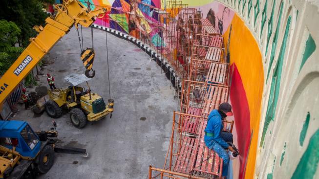 Pekerja menyelesaikan gambar mural bertema tokoh pewayangan di proyek Overpass Manahan, Solo, Jawa Tengah, Minggu (16/12). ANTARA FOTO/Mohammad Ayudha