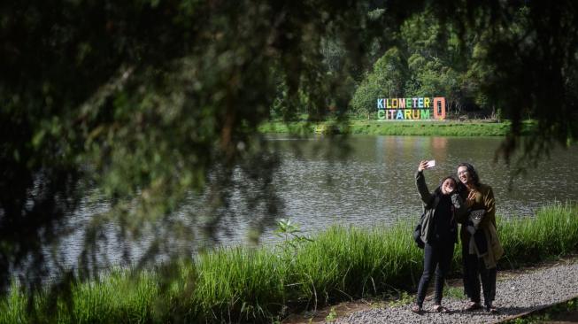 Pengunjung berswafoto di Danau Cisanti, Kabupaten Bandung, Jawa Barat, Senin (17/12). ANTARA FOTO/Raisan Al Farisi