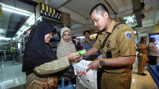 Petugas Dinas Lingkungan Hidup DKI Jakarta dan Perumda Pasar Jaya melakukan kegiatan operasi tukar kresek ke pembeli di Pasar Jaya Kramat Jati, Selasa (18/12). [Suara.com/Muhaimin A Untung]