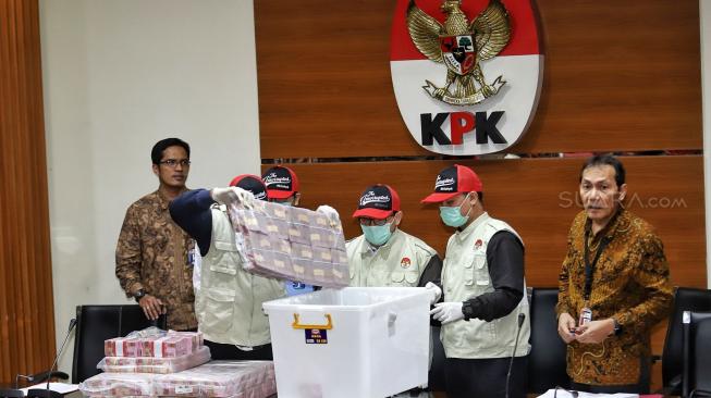 Wakil Ketua KPK saut Sitomorang dan Juru Bicara Febry Diansah bersama penyidik memperlihatkan barang bukti kasus suap terkait penyaluran dana hibah kepada KONI saat konferensi pers ott pejabat Kemenpora di Gedung KPK, Jakarta, Rabu (19/12). [Suara.com/Muhaimin A Untung]