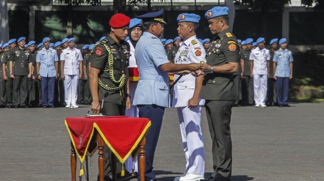 Panglima TNI Marsekal TNI Hadi Tjahjanto (ketiga kanan) menyerahkan tongkat komando kepada Komandan Pasukan Pengamanan Presiden (Paspampres) Brigjen TNI Maruli Simanjuntak (kanan) disaksikan Mayjen TNI (Mar) Suhartono (kedua kanan) pada acara serah terima jabatan Komandan Paspampres di Mako Paspampres, Jakarta, Rabu (19/12).. [ANTARA FOTO/Muhammad Adimaja]