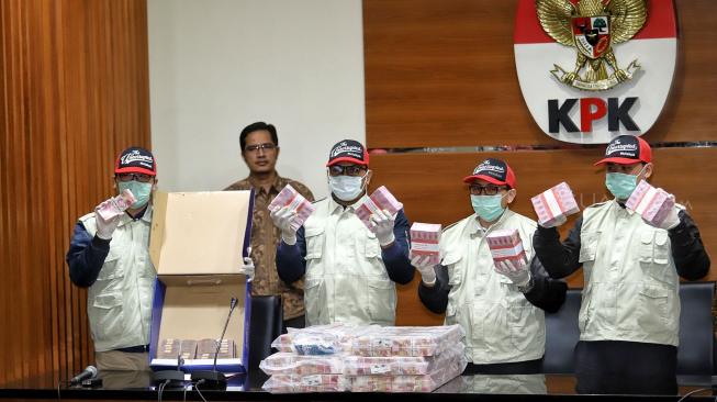 Juru Bicara Febry Diansah bersama penyidik memperlihatkan barang bukti kasus suap terkait penyaluran dana hibah kepada KONI saat konferensi pers ott pejabat Kemenpora di Gedung KPK, Jakarta, Rabu (19/12). [Suara.com/Muhaimin A Untung]