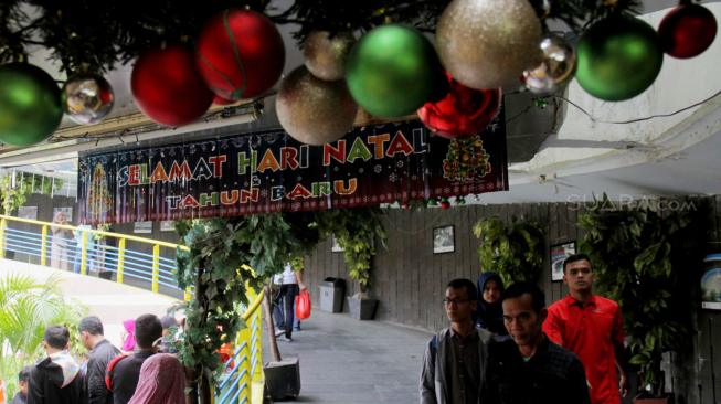 Pejalan kaki melintasi Terowongan Penyeberangan Orang (TPO) Kota Tua yang dihiasi pernak-pernik Natal, Jakarta Barat, Rabu, (19/12). [Suara com/Fakhri Hermansyah]