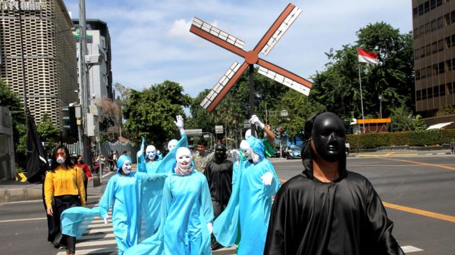 Sejumlah aktivis dari #BersihkanIndonesia melakukan aksi teatrikal di lintasan penyeberangan Jalan Sarinah, Jakarta Pusat, Kamis (20/12). [Suara.com/Fakhri Hermansyah]