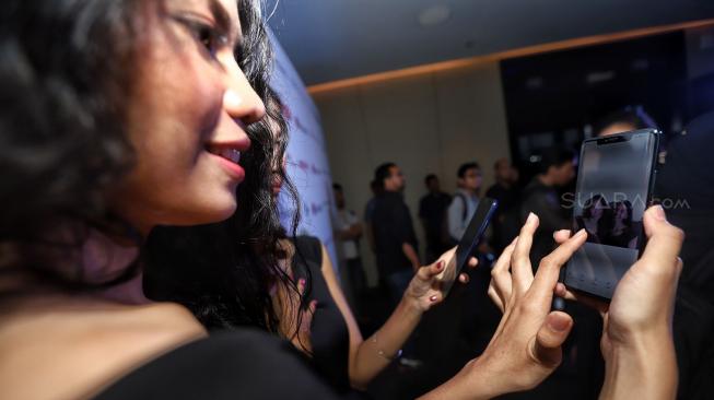 Model mencoba smartphone terbaru Mate 20 Series dari Huawei saat peluncuran perdana di Hotel Westin, Jakarta, Rabu (19/12). [Suara.com/Muhaimin A Untung]