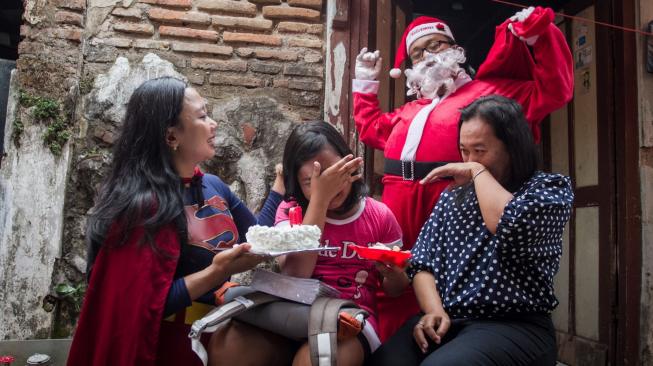 Warga berkostum Sinterklas dan Superhero membawa hadiah untuk memberikan kejutan Natal sekaligus ulang tahun kepada anak di Solo, Jawa Tengah, Jumat (21/12). ANTARA FOTO/Mohammad Ayudha