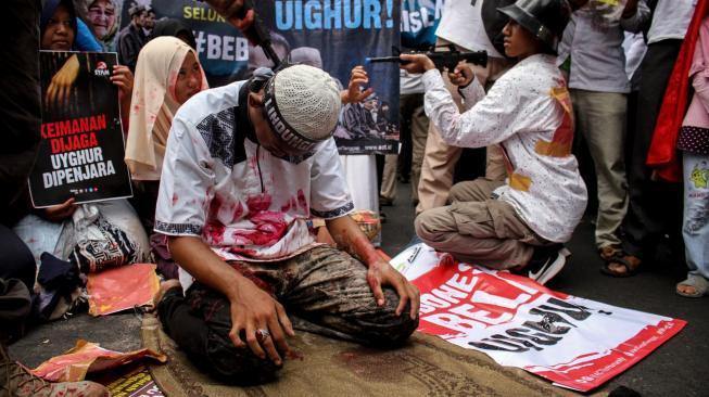 Pengunjuk rasa dari berbagai organisasi Islam menggelar aksi solidaritas terhadap Muslim Uighur di depan Kedubes Cina, Jakarta, Jumat (21/12). ANTARA FOTO/Putra Haryo Kurniawan