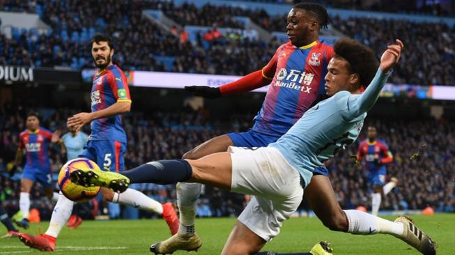 Gelandang Manchester City Leroy Sane bersaing dengan gelandang Crystal Palace Aaron Wan-Bissaka selama pertandingan sepak bola Liga Primer Inggris antara Manchester City melawan Crystal Palace di Stadion Etihad, Manchester, Inggris, Sabtu (22/12). [Oli SCARFF / AFP]