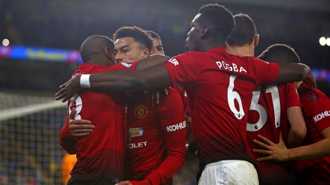 Pemain tengah Manchester United Jesse Lingard merayakan golnya dengan rekan satu timnya setelah mencetak gol keempat mereka dari titik penalti selama pertandingan sepak bola Liga Inggris antara Cardiff City melawan Manchester United di Stadion Cardiff, Cardiff, Inggris, Minggu (23/12). [Geoff CADDICK / AFP]