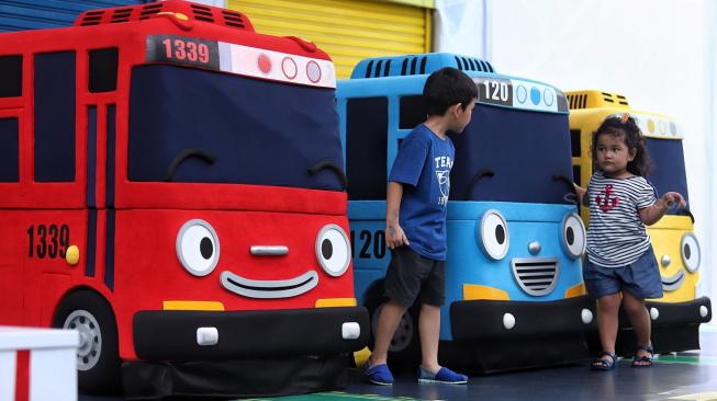 Sejumlah pengunjung berfoto dengan mobil karakter Tayo saat pertunjukan show spesial Tayo the Little Bus di Ocean Dream Taman Impian Jaya Ancol, Jakarta, Selasa (25/12).  [Suara.com/Muhaimin A Untung]