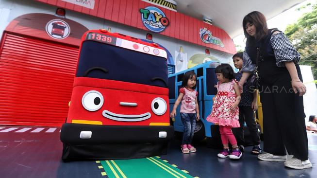 Sejumlah pengunjung berfoto dengan mobil karakter Tayo saat pertunjukan show spesial Tayo the Little Bus di Ocean Dream Taman Impian Jaya Ancol, Jakarta, Selasa (25/12).  [Suara.com/Muhaimin A Untung]