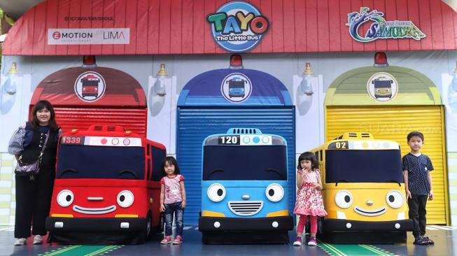 Sejumlah pengunjung berfoto dengan mobil karakter Tayo saat pertunjukan show spesial Tayo the Little Bus di Ocean Dream Taman Impian Jaya Ancol, Jakarta, Selasa (25/12).  [Suara.com/Muhaimin A Untung]