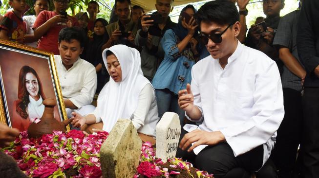 Vokalis band Seventeen, Riefian Fajarsyah alias Ifan (kanan) berdoa di makam istrinya Dylan Sahara seusai pemakaman di Tempat Pemakaman Umum Tamanarum, Kabupaten Ponorogo, Jawa Timur, Selasa (25/12). [ANTARA FOTO/Siswowidodo]