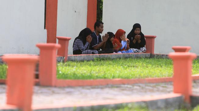 Sejumlah umat muslim membaca Surat Yasin dan doa bersama saat berziarah ke kuburan massal korban gempa dan gelombang tsunami di Desa Suak Indrapuri, Johan Pahlawan, Aceh Barat, Aceh, Rabu (26/12). [ANTARA FOTO/Syifa Yulinnas]