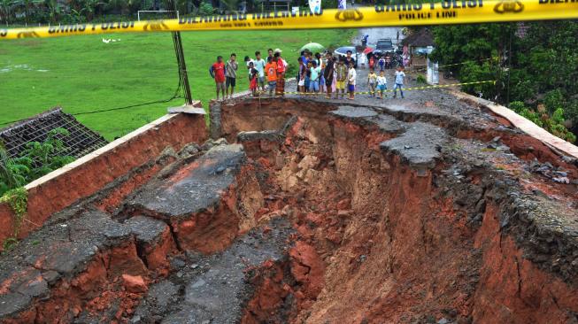 Sejumlah warga melihat jalan tepi jembatan yang ambles di Kampung Leuwi Jaksi, Cimarga, Lebak, Banten, Rabu (26/12). [ANTARA FOTO/Muhammad Bagus Khoirunas]