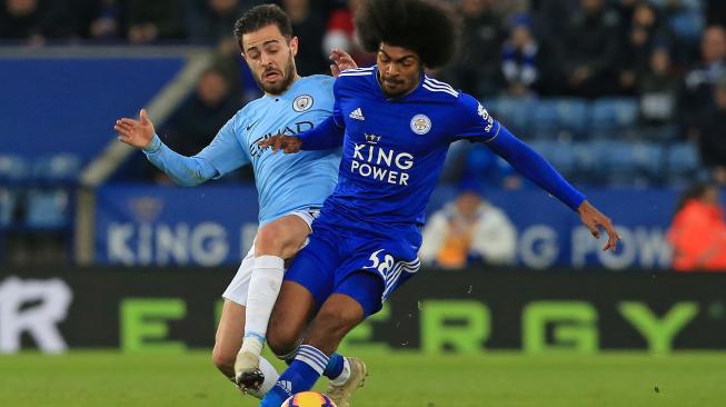 Gelandang Manchester City Bernardo Silva bersaing dengan gelandang Leicester Hamza Choudhury selama pertandingan sepak bola Liga Premier Inggris antara Leicester  melawan Manchester City  di Stadion King Power, Leicester, Inggris, Rabu (26/12). [Lindsey PARNABY / AFP]