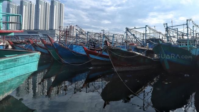 Nelayan beraktifitas di perahu nelayan saat bersandar di Pelabuhan Muara Angke, Jakarta, Kamis (27/12). [Suara.com/Muhaimin A Untung]