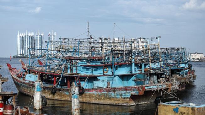 Nelayan beraktifitas di perahu nelayan saat bersandar di Pelabuhan Muara Angke, Jakarta, Kamis (27/12). [Suara.com/Muhaimin A Untung]