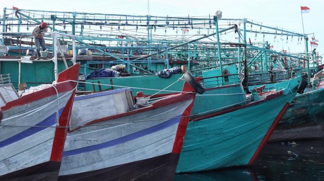 Nelayan beraktifitas di perahu nelayan saat bersandar di Pelabuhan Muara Angke, Jakarta, Kamis (27/12). [Suara.com/Muhaimin A Untung]