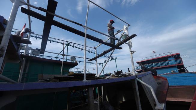 Nelayan beraktifitas di perahu nelayan saat bersandar di Pelabuhan Muara Angke, Jakarta, Kamis (27/12). [Suara.com/Muhaimin A Untung]