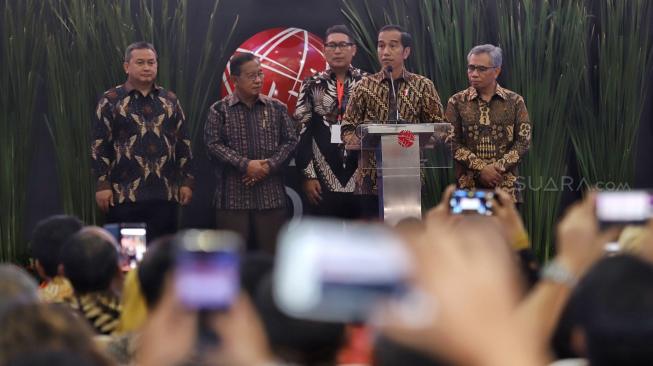 Presiden Joko Widodo (kiri) didampingi Menko Perekonomian Darmin Nasution (kedua kiri), Ketua Dewan Komisioner OJK Wimboh Santoso (tengah), Kepala Eksekutif Pengawas Pasar Modal OJK Hoesen (kedua kanan) dan Dirut PT Bursa Efek Indonesia Inarno Djajadi melakukan seremoni penutupan Indeks Harga Saham Gabungan (IHSG) 2018 di kantor Bursa Efek Indonesia, Jakarta, Jumat (28/12). [Suara.com/Muhaimin A Untung]