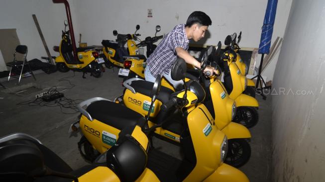 Petugas melakukan pengisian daya sepeda listrik Migo di kawasan Menteng, Jakarta Pusat, Jumat (28/12). [Suara.com/Fakhri Hermansyah]