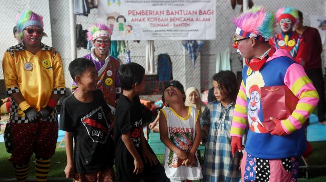 Badut dari Aku Badut Indonesia menghibur anak korban bencana tsunami di pengungsian Labuan, Pandeglang, Banten, Kamis (27/1).[ANTARA FOTO/Akbar Nugroho Gumay]