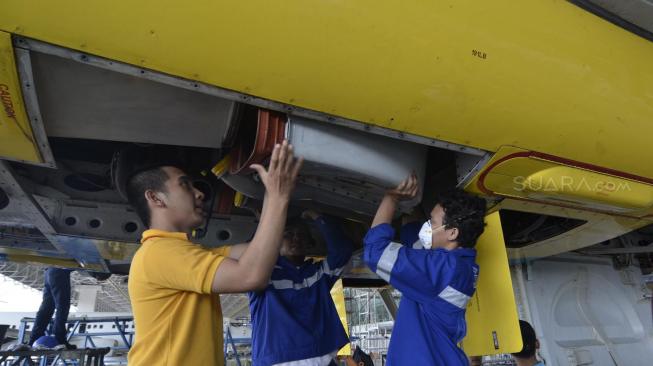 Petugas saat melakukan perawatan Pesawat di Hanggar  GMF Aeroasia, Tangerang, Banten, Jum'at (28/12).[Suara.com/Fakhri Hermansyah]