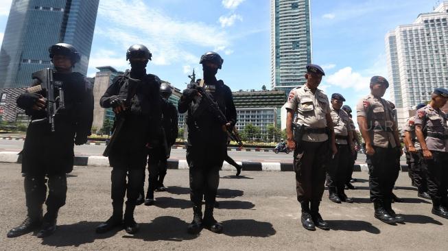 Sejumlah satuan Brimob dan Sabhara Polda Metro Jaya berjaga di sekitar kawasan Bundaran HI, jakarta, Minggu (30/12). [Suara.com/Muhaimin A Untung]