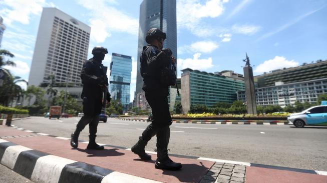 Sejumlah satuan Brimob dan Sabhara Polda Metro Jaya berjaga di sekitar kawasan Bundaran HI, jakarta, Minggu (30/12). [Suara.com/Muhaimin A Untung]