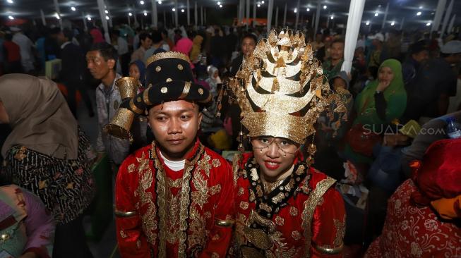 Pasangan pengantin mengikuti nikah massal di Thamrin Park ride, Jakarta, Senin (31/12). [Suara.com/Muhaimin A Untung]