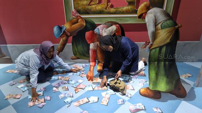 Pengunjung menikmati suasana mural dan ilusi Museum Magic Art 3D, di kawasan wisata Kota Tua, Jakarta, Senin (31/12). [Suara.com/Muhaimin A Untung]