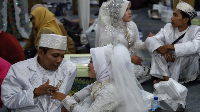 Pasangan pengantin mengikuti nikah massal di Thamrin Park ride, Jakarta, Senin (31/12). [Suara.com/Muhaimin A Untung]