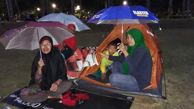 Sejumlah masyarakat rela mendirkan tenda untuk merayakan Tahun Baru 2019 d kawasan Monas. (Suara.com/Risna Halidi)