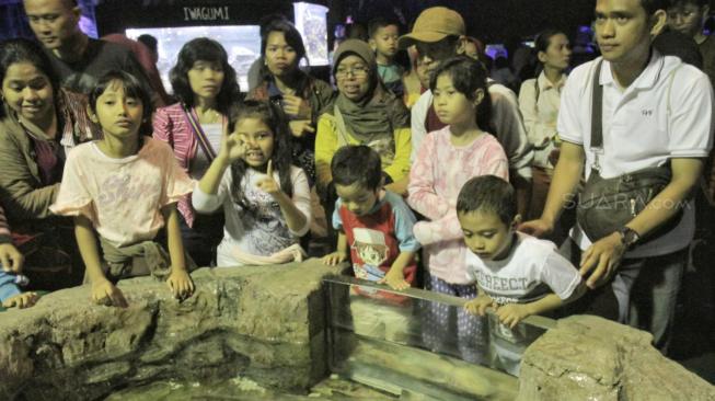 Sejumlah anggota Komunitas Advokasi Difabel Indonesia (KADI) bersama keluarga saat mengikuti wisata di wahana SeaWorld Ancol, Jakarta Utara, Selasa (1/1). [Suara.com/Fakhri Hermansyah]