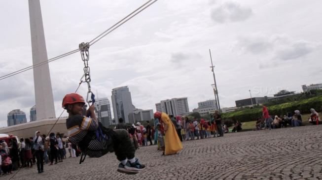 Warga memadati kawasan Monumen Nasional (Monas), Jakarta Pusat, Selasa (1/1). [Suara.com/Fakhri Hermansyah]