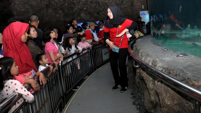 Sejumlah anggota Komunitas Advokasi Difabel Indonesia (KADI) bersama keluarga saat mengikuti wisata di wahana SeaWorld Ancol, Jakarta Utara, Selasa (1/1). [Suara.com/Fakhri Hermansyah]