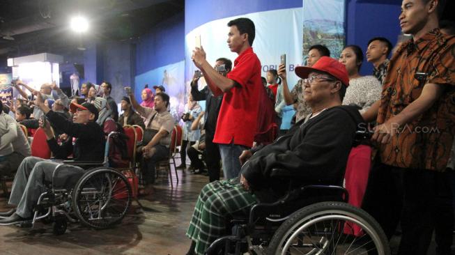 Sejumlah anggota Komunitas Advokasi Difabel Indonesia (KADI) bersama keluarga saat mengikuti wisata di wahana SeaWorld Ancol, Jakarta Utara, Selasa (1/1). [Suara.com/Fakhri Hermansyah]