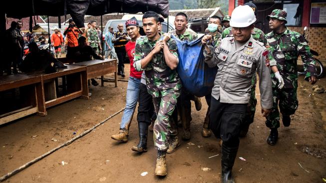 Petugas gabungan membawa korban longsor di kampung Cimapag, Desa Sirnaresmi, Kecamatan Cisolok, Kabupaten Sukabumi, Jawa Barat, Rabu (2/1). [ANTARA FOTO/M Agung Rajasa]