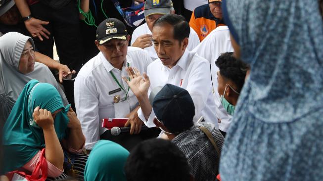 Presiden Joko Widodo (tengah) berdialog dengan warga ketika mengunjungi lokasi terdampak tsunami Selat Sunda di Desa Kunjir, Rajabasa Lampung Selatan, Lampung, Rabu (2/1). [ANTARA FOTO/Wahyu Putro]