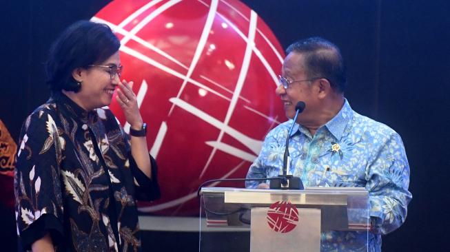 Menteri Koordinator Bidang Perekonomian Darmin Nasution (kanan) berbincang dengan Menteri Keuangan Sri Mulyani (kiri) saat pembukan perdagangan 2019 di Bursa Efek Indonesia, Jakarta, Rabu (2/1). [ANTARA FOTO/Akbar Nugroho Gumay]