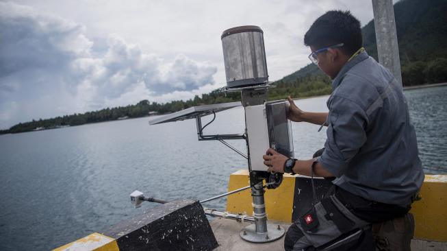 Petugas BMKG memasang alat pengukur ketinggian air atau "water level" saat berlangsung erupsi Gunung Anak Krakatau (GAK) di Pelabuhan Pulau Sebesi, Lampung Selatan, Lampung, Selasa (1/1). [ANTARA FOTO/Sigid Kurniawan]