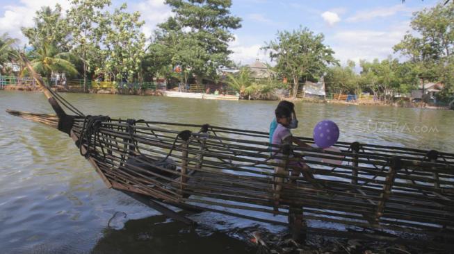 Pengunjung beraktivitas di areal Wisata Konservasi Hutan Bambu di bantaran Kali Bekasi, Bekasi, Jawa Barat, Kamis (3/1). [Suara.com/Fakhri Hermansyah]