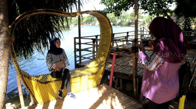 Pengunjung beraktivitas di areal Wisata Konservasi Hutan Bambu di bantaran Kali Bekasi, Bekasi, Jawa Barat, Kamis (3/1). [Suara.com/Fakhri Hermansyah]