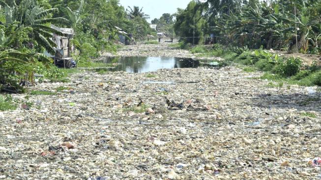 Suasana Kali Pisang Batu yang dipenuhi sampah di desa Pahlawan Setia, Bekasi, Jawa Barat, Jumat (4/1).   [Suara.com/Fakhri Hermansyah]