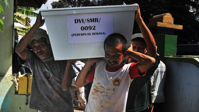 Warga bersama Tim DVI (Disaster Victim Investigation) Polda Banten yang mengangkat keranda jenazah saat Pemakaman Korban Tsunami tak teridentifikasi (tak dikenal) di TPU (Tempat Pemakaman Umum) Ninik-Aki di Cigadung, Pandeglang, Banten, Jumat (4/1). [ANTARA FOTO/Asep Fathulrahman]