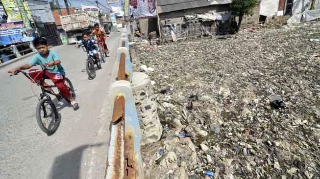 Suasana Kali Pisang Batu yang dipenuhi sampah di desa Pahlawan Setia, Bekasi, Jawa Barat, Jumat (4/1).   [Suara.com/Fakhri Hermansyah]